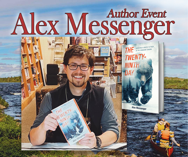 Author with book and canoes behind him